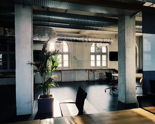 A modern office space in Warsaw, Poland, showing desks and a plant